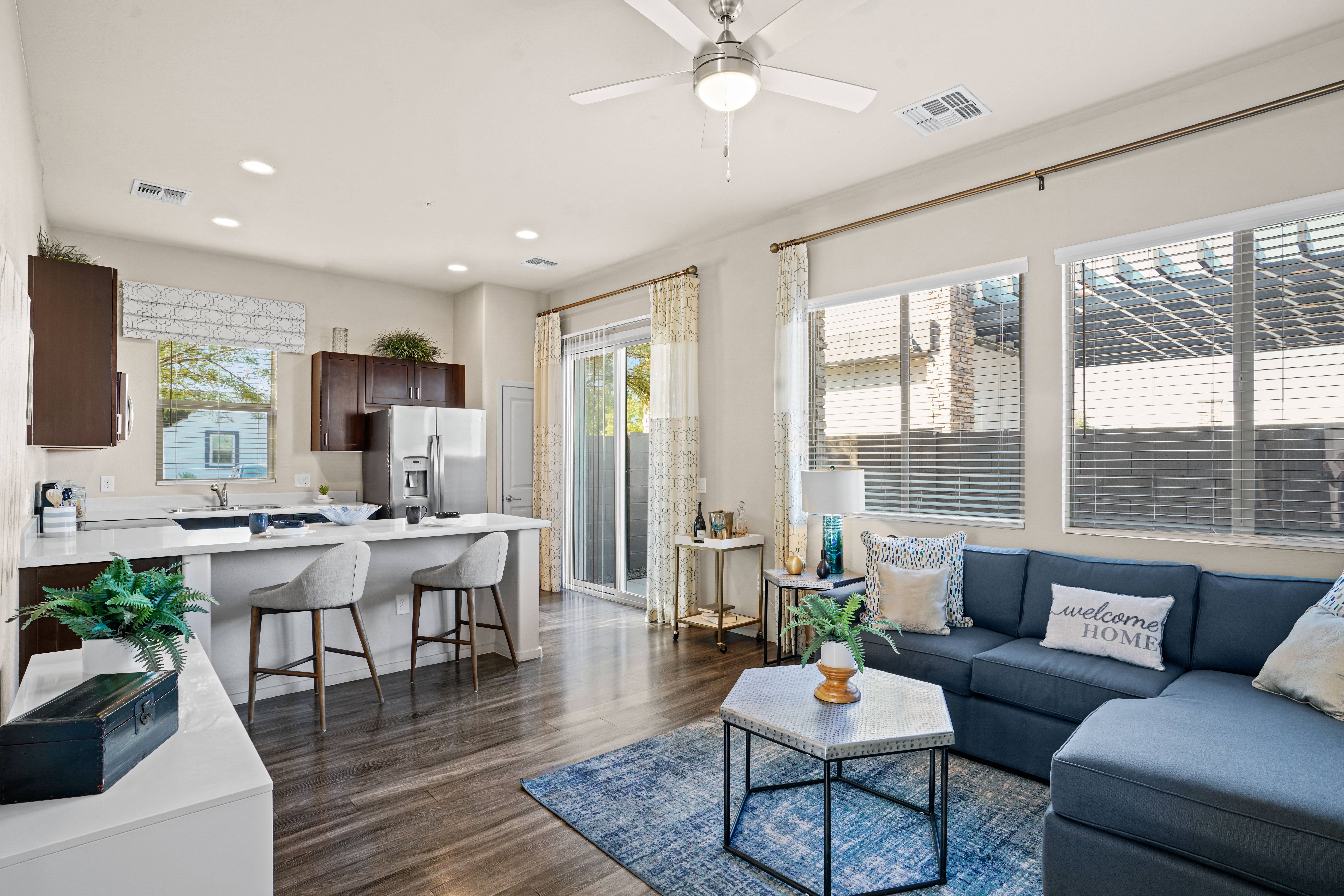 an open living room and kitchen with a blue couch and a coffee table at Olive Queen Creek Apartments, Queen Creek, 85142